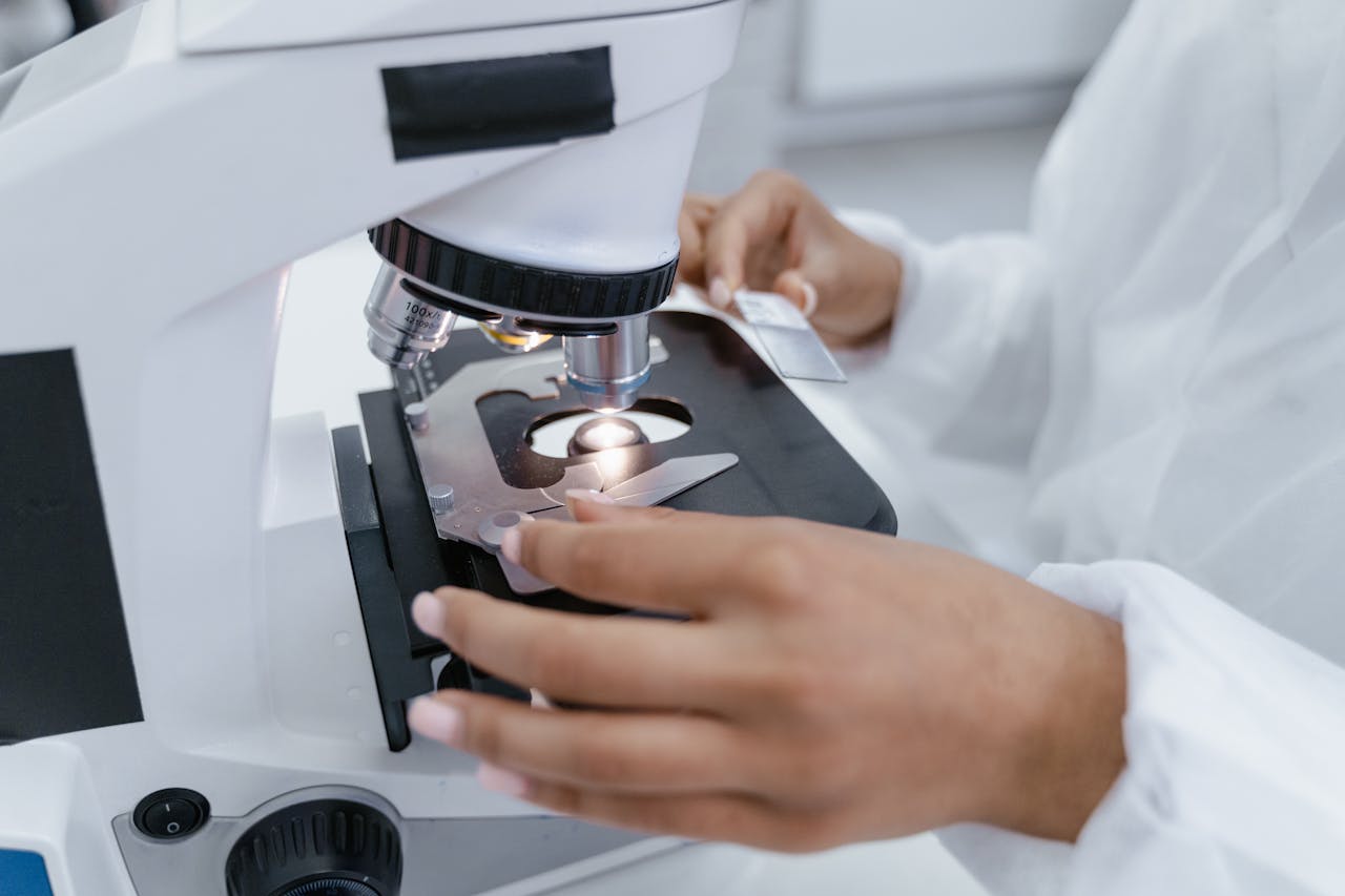 about-us Scientist in laboratory using a microscope for detailed sample analysis.